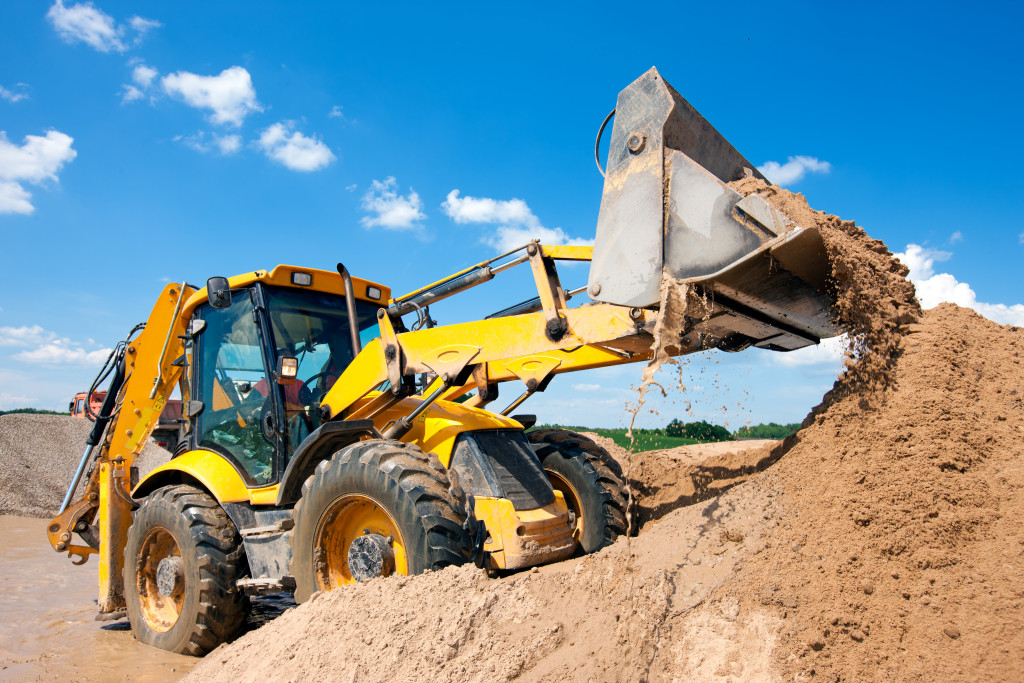 excavator carrying mounds of soil