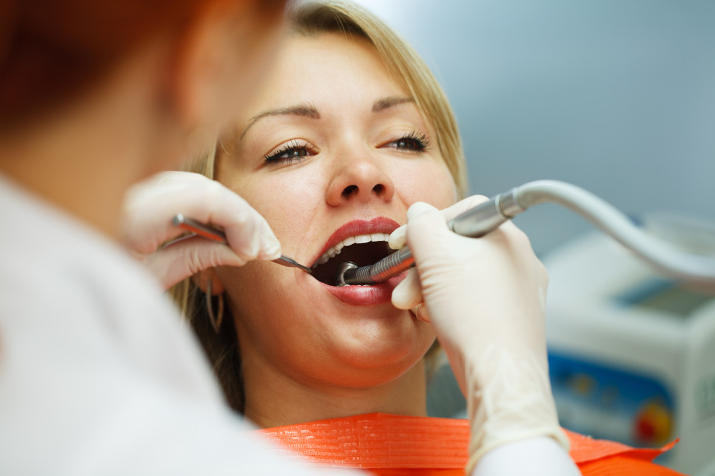 Dentist performing Interdental brushes treatment on a woman in clinic