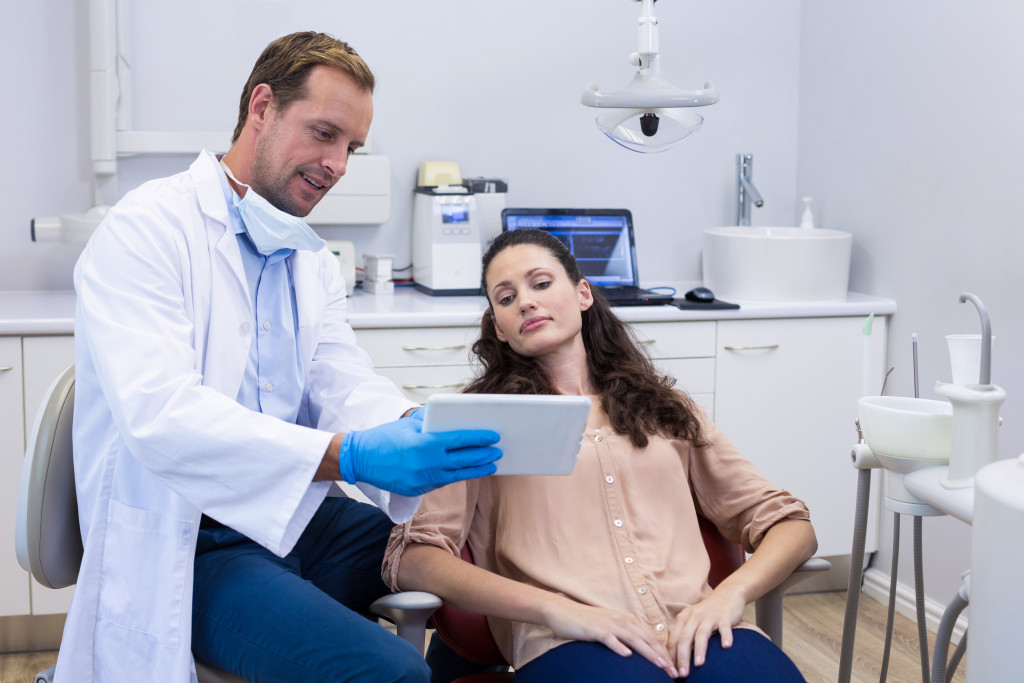 a dentist showing patient a digital tablet 