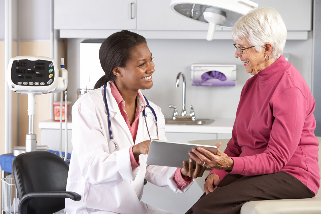 a modern healthcare provider talking to a patient using a digital tablet