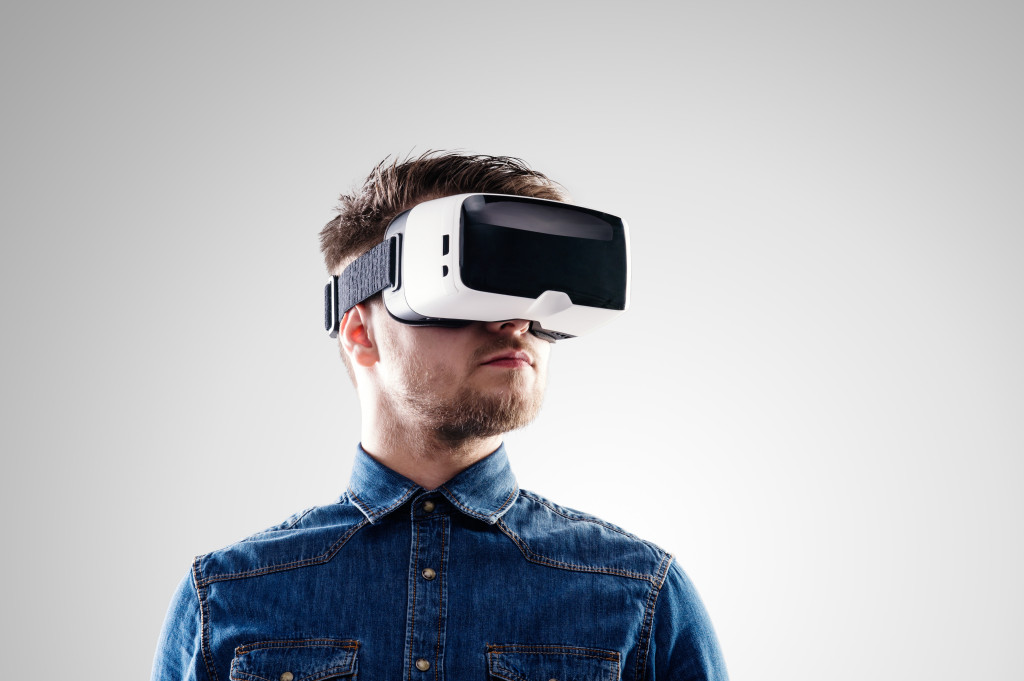 A man wearing VR glasses on a gray background