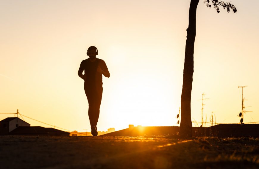 a silhouette of a man jogging during the sunrise